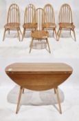 Ercol dining room suite comprising a pale elm and beech oval drop flap dining table on square
