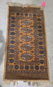Eastern gold/tan ground rug with one row of five geometric medallions, multiple geometric and floral