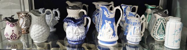 Collection of Victorian pottery relief-moulded jugs including blue and white Parian examples by