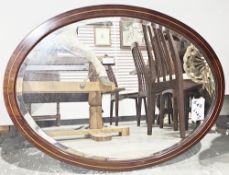 Edwardian mahogany inlaid oval framed wall mirror, the plate with bevelled edge, 78cm x 58cm