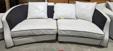 Contemporary white leather and black fabric sofa of curved form, modular coming in two sections,