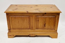 Modern pine blanket box, the hinged lid over two-panel front, on bracket feet, 63cm high x 108cm