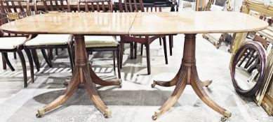 Regency mahogany twin-pedestal dining table, the top with rounded ends and one additional leaf, on