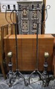 Pair of wrought iron floor standing three branch candle holders, on twisted stems and three