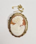 Shell cameo brooch of oval form depicting a lady with flowers in her hair, in gold-coloured engraved