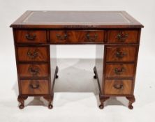 Reproduction mahogany small kneehole desk with leatherette inset top and an arrangement of nine