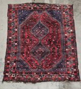 Large Eastern red ground rug with two large conjoined geometric medallions on geometric pattern