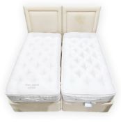 Pair of Sovereign single divan beds, upholstered in a cream fabric, two Helios single headboards