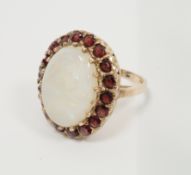 9ct gold, opal and garnet cluster ring, the central oval opal surrounded by 18 garnets, finger