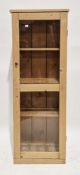 Late 19th/early 20th century pine cabinet, the single glazed panel door opening to three fixed