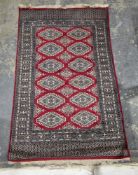 Eastern red ground rug with two rows of six large hooked lozenges and one row of five hooked