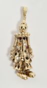 Substantial 9ct gold articulated clown pendant, the face set with emerald eyes, his robe gem set