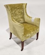 Early 20th century wing back armchair upholstered in a lime green velvet, on square tapering legs