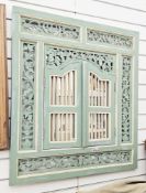 South east Asian painted wooden shutter mirror, having pierced foliate scroll frame and two
