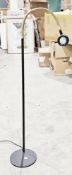 Serious floor standing reading lamp with brass-effect and black metal swan-neck adjustable column on