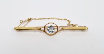 15ct gold and bluestone bar brooch, the circular claw-set stone within pierced circular surround,
