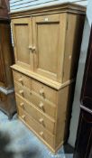 19th century pine cupboard on chest, the upper section with two panel doors opening to a single
