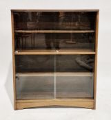 In the manner of Herbert Gibbs a mid-century oak library bookcase with two pairs of glass sliding