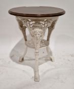 Pub table with circular mahogany top, on a white painted cast iron base, the three legs decorated