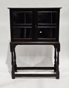 Oak cabinet having two doors, each with two cockbeaded glazed panels opening to a single fixed