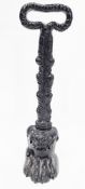 19th century cast iron doorstop/porter in the form of a lions paw, with foliate stem and loop