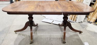 Regency-style mahogany extending dining room table, the rectangular top with rounded ends, on twin