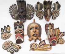 Four Sri Lankan or Indonesian Garuda painted wooden face masks, three carved with snakes and the