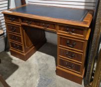 Yew wood twin-pedestal desk, the rectangular top with leather inset writing surface, over an