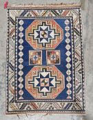 Large blue ground rug with two central square medallions flanked by large elephant foot guls and two
