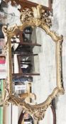 19th century giltwood and gesso wall mirror in the Rococo manner, the shaped frame with foliate