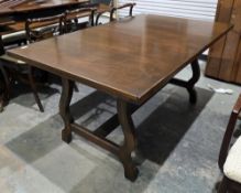 Stained ash refectory-style dining table on lyre end supports, extending with one additional pull-