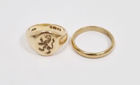 9ct gold signet ring engraved with a lion crest, finger size I½ and a 9ct gold wedding band,