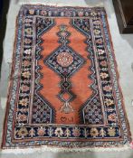 Eastern red ground rug with central lozenge and floral motif, floral spandrels and multiple