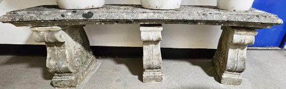 Composite stone garden bench of curved form, on three supports, moulded with grapes and vine leaves,