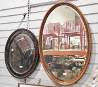 Early 20th century mahogany oval wall mirror, the plate with bevelled edge, 89cm long together