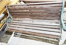 Wooden slatted garden bench with curved seat and back and green metal ends, 70cm high x 126cm long x