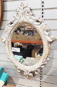 Modern limed-effect wooden framed oval mirror in the rococo style, 84cm high x 60cm wide
