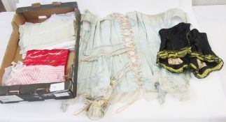 A vintage blue satin corset combining suspenders, a black corset trimmed with black sequins and