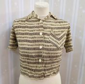 A crepe 1940's blouse, pale ochre, printed with a brown repeat pattern, 'V' shaped breast pocket,
