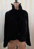 A 1920's black velvet jacket, with ruched sleeves, a quilted stand-up collar, single button