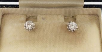 Pair of white metal single stone diamond stud earrings, the central brilliant cut diamonds (total