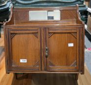 Late 19th/early 20th century oak hanging cupboard, the mirrored back rail over two cupboard doors