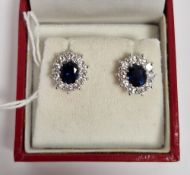 Pair of sapphire and diamond cluster stud earrings, each oval cut central sapphire (total weight 1.
