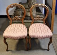 Pair of Victorian mahogany balloon back chairs, with foliate scroll carved back, pink patterned