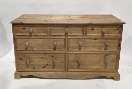 Modern pine chest having an arrangement of seven drawers with turned wooden handles, on bracket