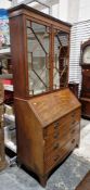 19th century mahogany and crossbanded bureau bookcase, the cornice with dentil moulding over two