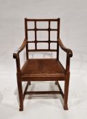In the manner of the Cotswold School an Arts and Crafts pale oak elbow chair with lattice back,