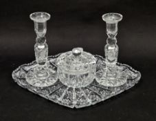20th century cut glass lozenge-shaped tray and two candlesticks cut with starbursts and faceting,