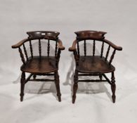 Two 19th century elm seated captain's bow elbow chairs with turned spindle backs, turned baluster