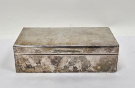 Silver cigarette box, marks rubbed, of plain rectangular form, the hinged cover with presentation